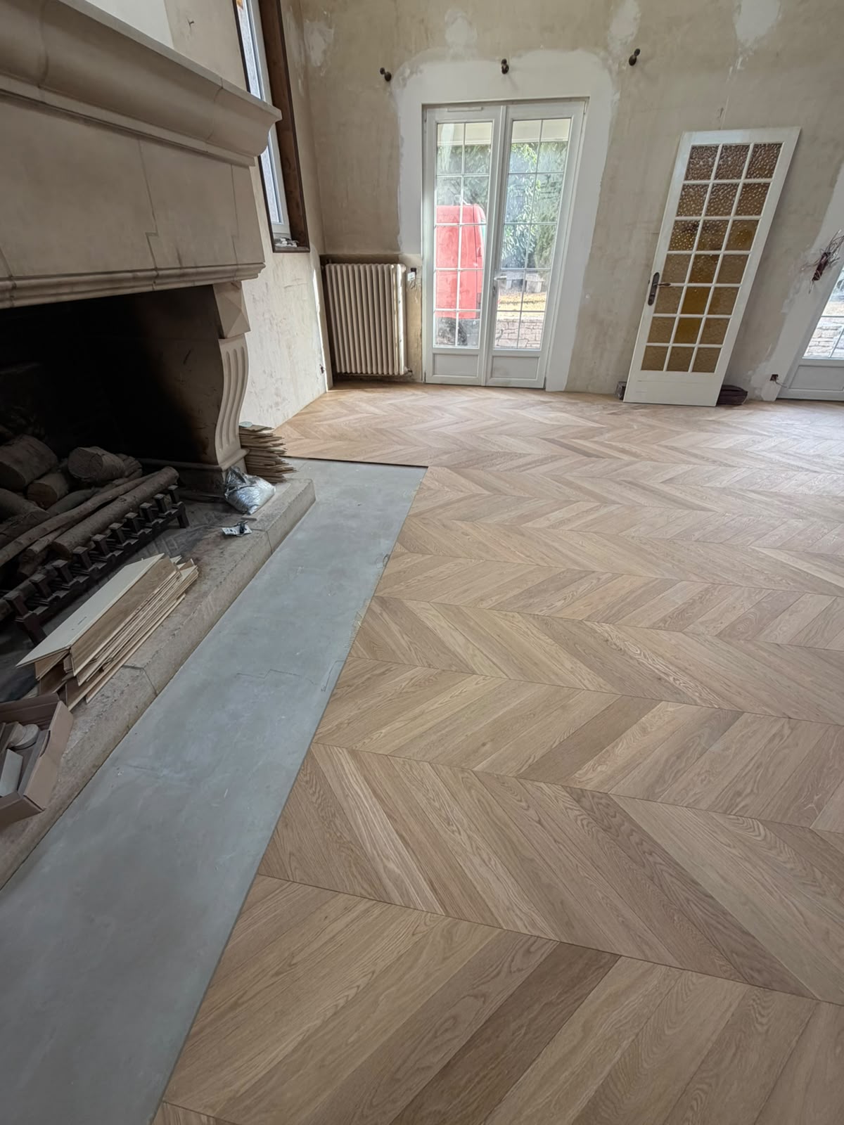 Salle à manger avec parquet contrecollé chêne en pointe de Hongrie collé, cheminée en pierre et portes-fenêtres (NATURABOIS, artisan à Orléans)